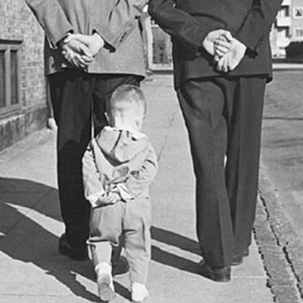 Toddler follows two men in suits, copying gestures - 1950's
