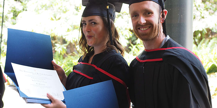 New grads showing diplomas