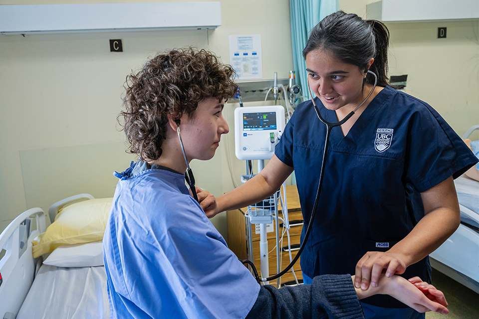 Student nurse checks heartbeat of young adult patient