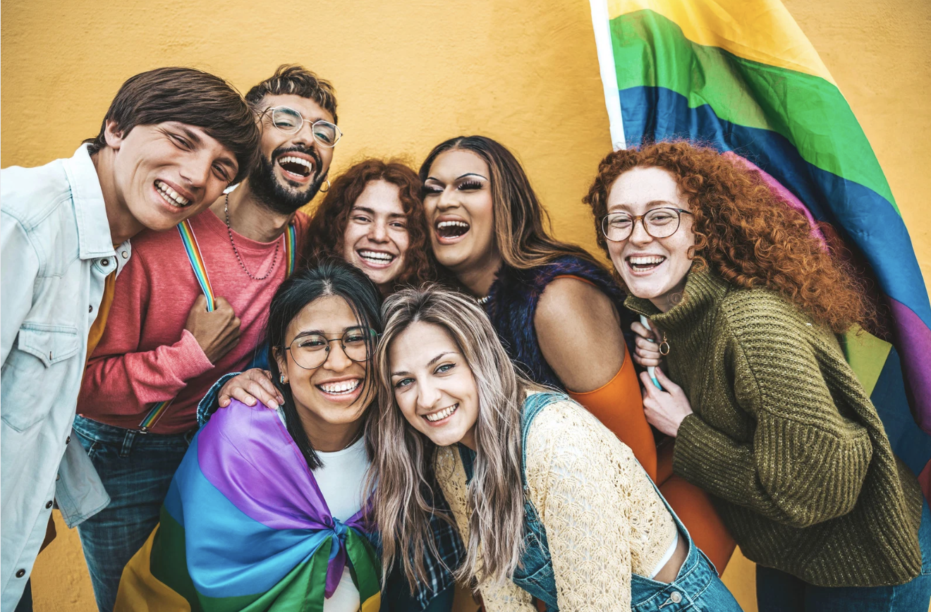 Group of youth smiling with pride flag