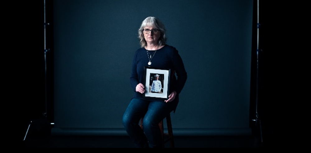 Woman holding a portrait of her child