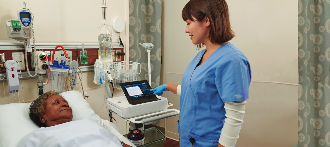 Technician operates ECG machine at patient bedside