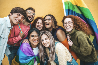 Group of youth smiling with pride flag