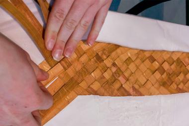 Hands weave a cedar band