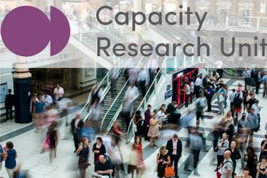 Busy crowd of people overlaid with Capacity Research Unit logo