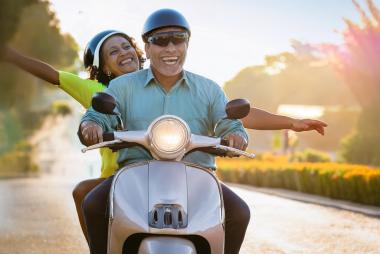 Seniors enjoying a ride on a moped