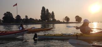 VSP students paddle kayaks in False Creek area of Vancouver as the sun sinks toward the horizon