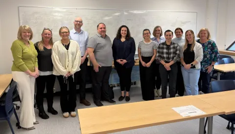Faculty and students from the UK pose in a classroom with Fairleth McCuaig