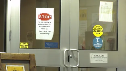 A sign hangs at the entrance of a B.C. long-term care home prohibiting visitors during the COVID-19 pandemic. 