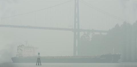 Tanker passes under the Lion's Gate Bridge in grey fog