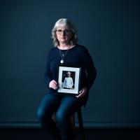 Woman holding a portrait of her child